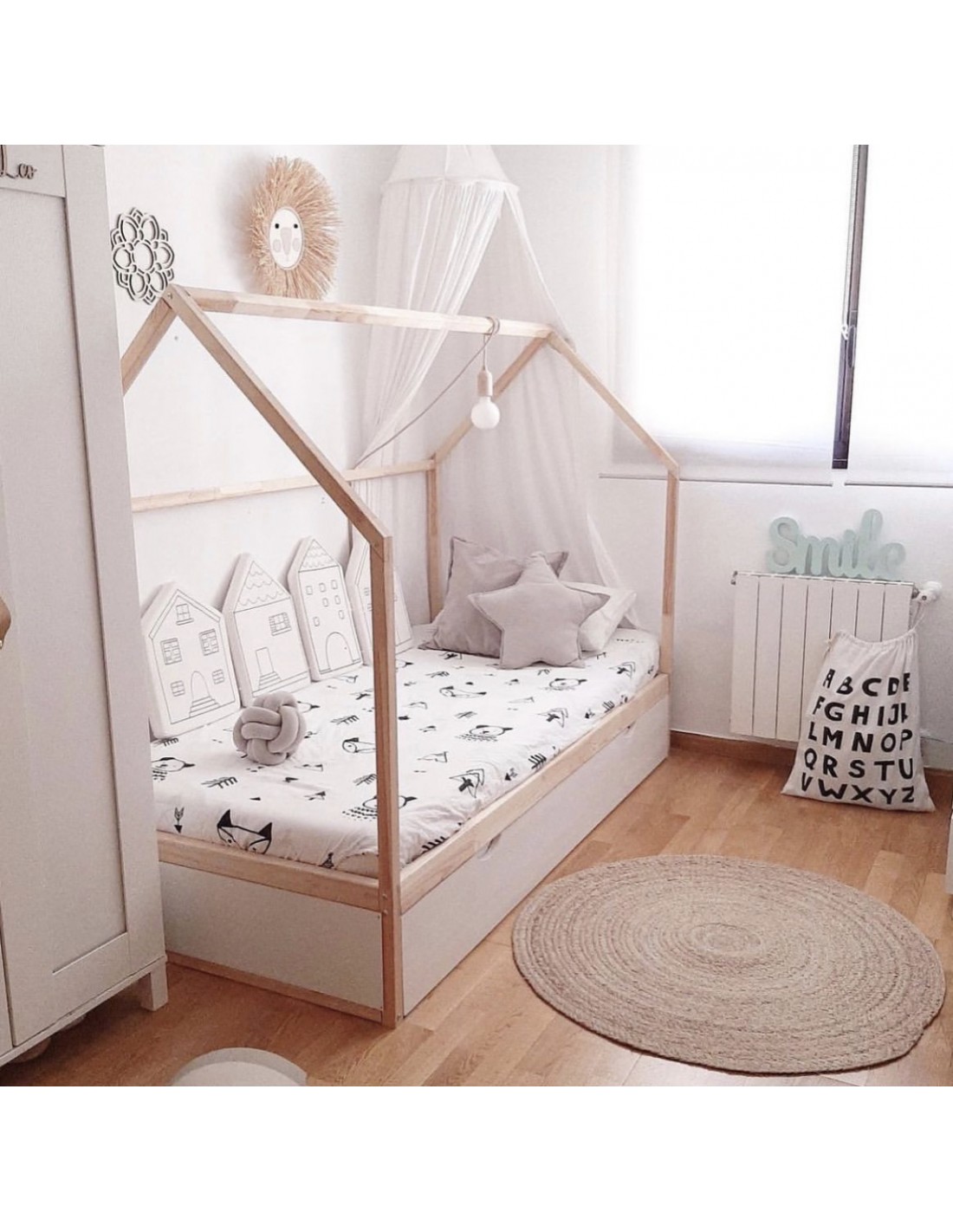 Habitación infantil con cama dosel y nido de cajones..